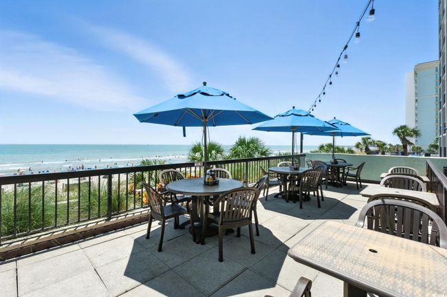 View of patio / terrace with outdoor dining space and view of water and beach | Image 25