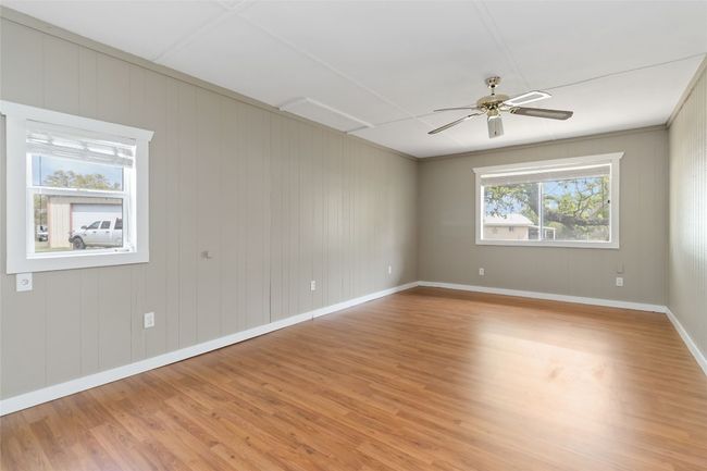 Unfurnished room with baseboards, light wood finished floors, and ceiling fan | Image 13