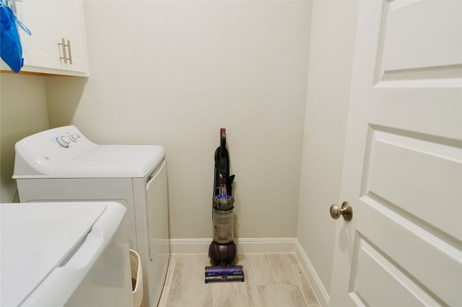 Laundry area featuring washing machine and clothes dryer and cabinet space | Image 20