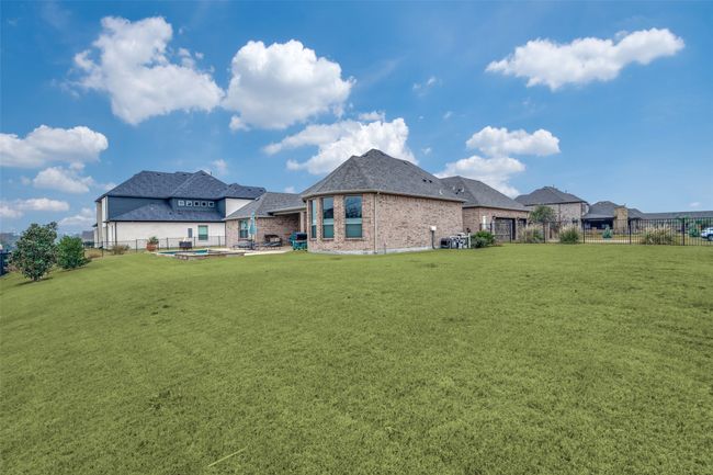 Sitting on almost 1/2 acre lot, there is a large back and side yard that could accommodate a trampoline or play ground equipment. You can also see where the pool equipment is located. | Image 29