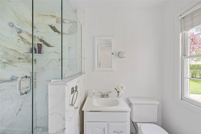 Full bathroom featuring toilet, a marble finish shower, and vanity | Image 14