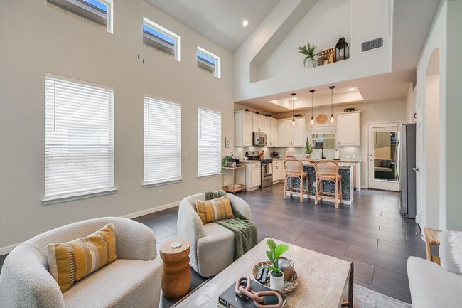 Living room featuring a towering ceiling, recessed lighting, dark tile patterned flooring, and baseboards | Image 11
