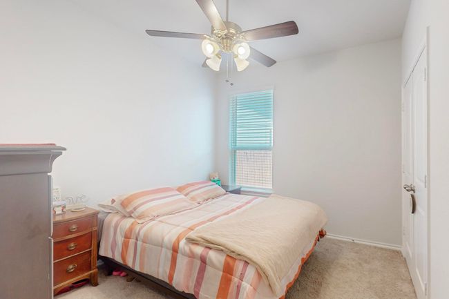 Bedroom with ceiling fan, a closet, light colored carpet, and baseboards | Image 9