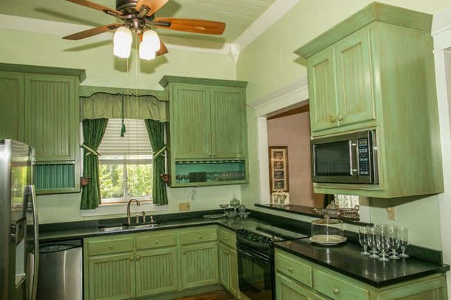 Kitchen featuring appliances with stainless steel finishes, green cabinets, and dark countertops | Image 14