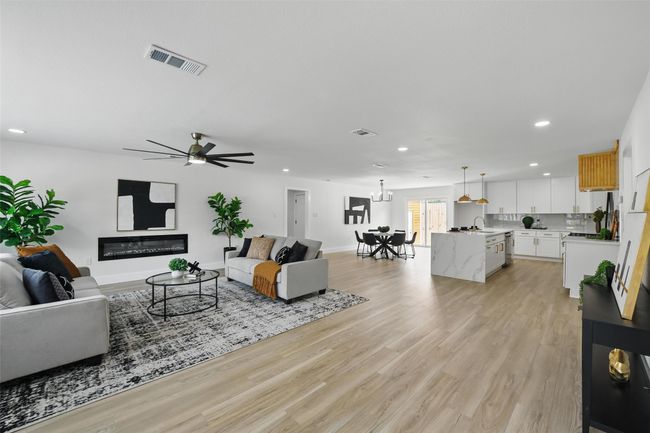 Living room featuring recessed lighting, light wood-style flooring, ceiling fan, a chandelier, and baseboards | Image 4