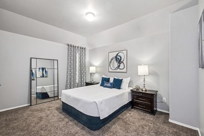 Bedroom with dark carpet, baseboards, and lofted ceiling | Image 32