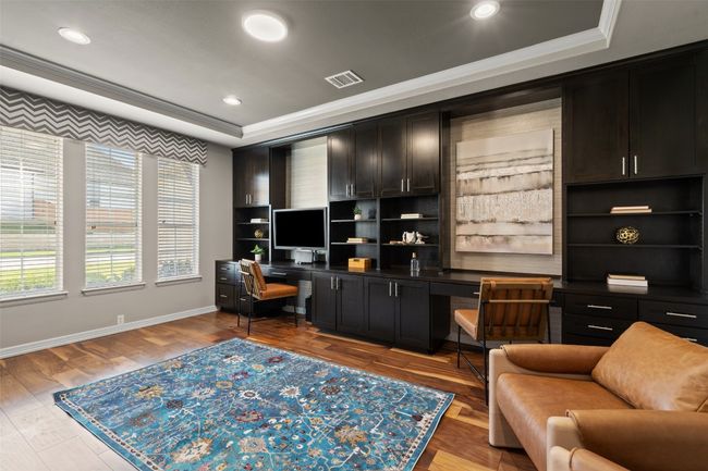 Office with crown molding, baseboards, a raised ceiling, visible vents, and wood finished floors | Image 11