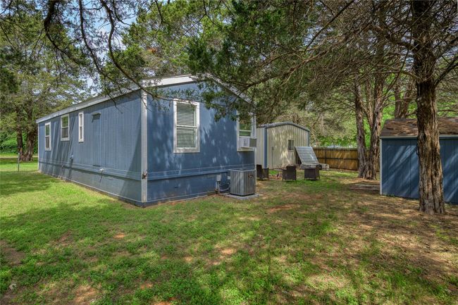 View of side of property with a shed, an outdoor structure, central AC, cooling unit, and crawl space | Image 10