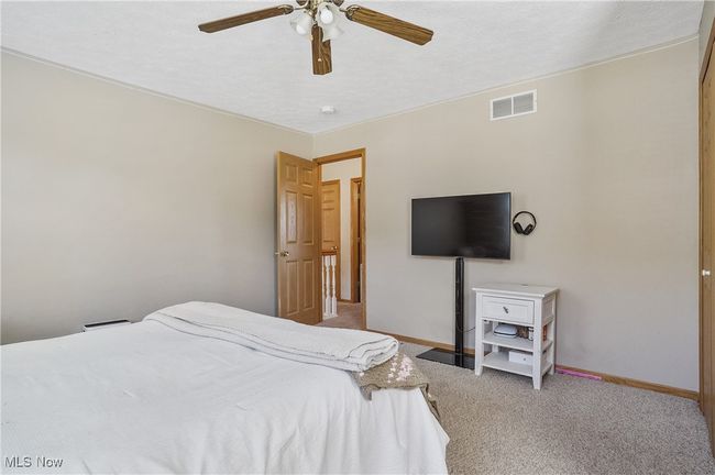 Bedroom featuring visible vents, ceiling fan, baseboards, and light carpet | Image 33
