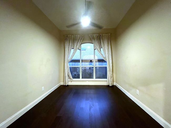 Spare room featuring dark wood-type flooring and ceiling fan | Image 16