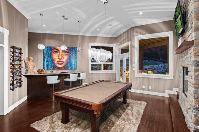 Rec room with pool table, wood finished floors, and crown molding | Image 12