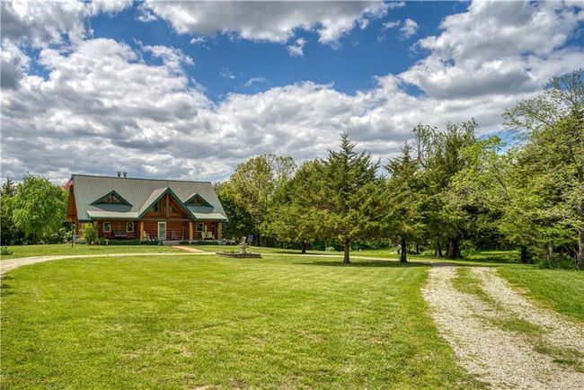 View of front of house featuring driveway, a front yard, and metal roof | Image 49