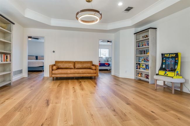 Living area with light wood-style flooring, visible vents, and a raised ceiling | Image 30