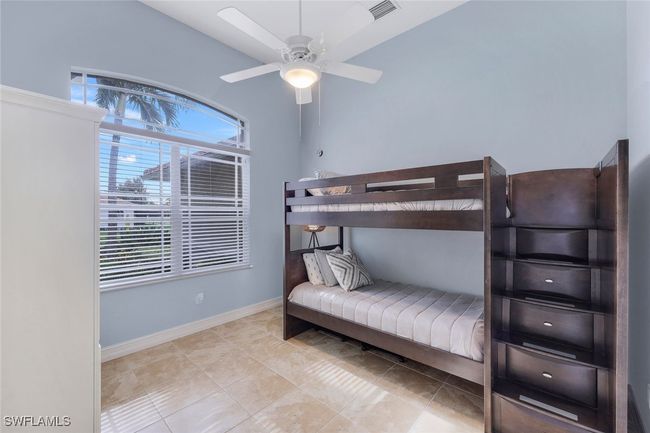 Bedroom with ceiling fan and light tile patterned floors | Image 17
