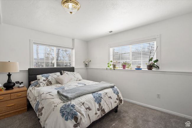 Carpeted bedroom with baseboards, visible vents, and a textured ceiling, and a Walk In closet | Image 27
