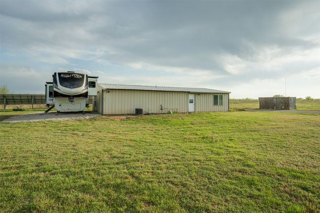 View of pole building featuring central air condition unit, a lawn, and fence | Image 37