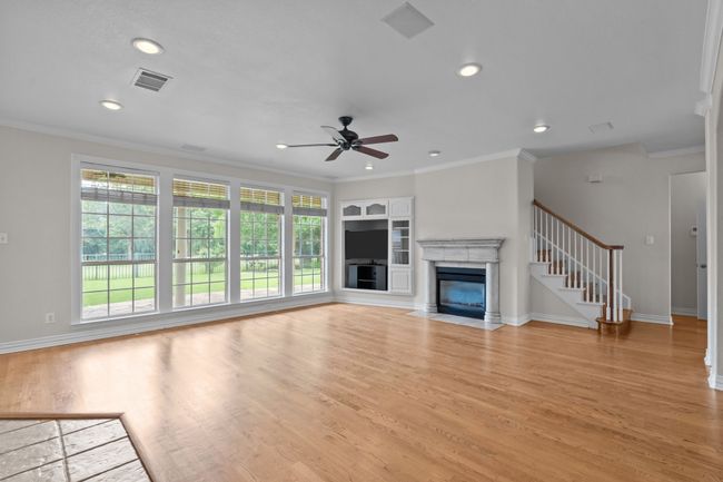 Oversized family room with traditional fire place and a wall of windows overlooking backyard | Image 8