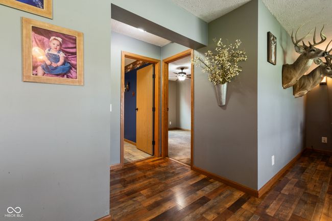 hallway with baseboards, a textured ceiling, and hardwood / wood-style floors | Image 32