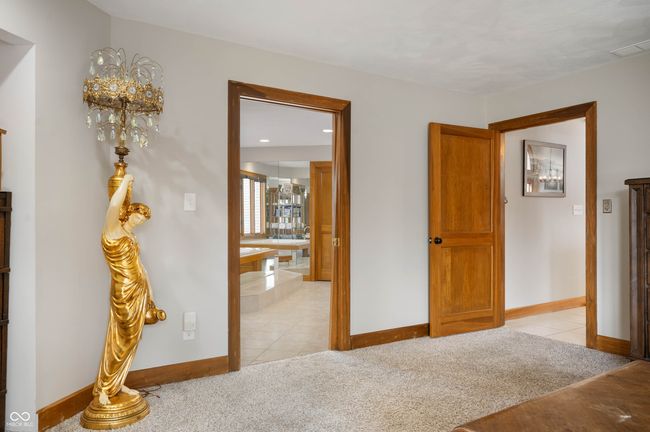 bedroom featuring light tile patterned flooring, light colored carpet, visible vents, and baseboards | Image 23