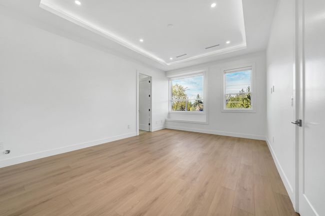 Unfurnished room featuring a tray ceiling, light wood-style flooring, baseboards, and recessed lighting | Image 16