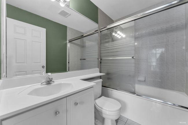 Full bathroom featuring visible vents, toilet, vanity, and shower / bath combination with glass door | Image 16