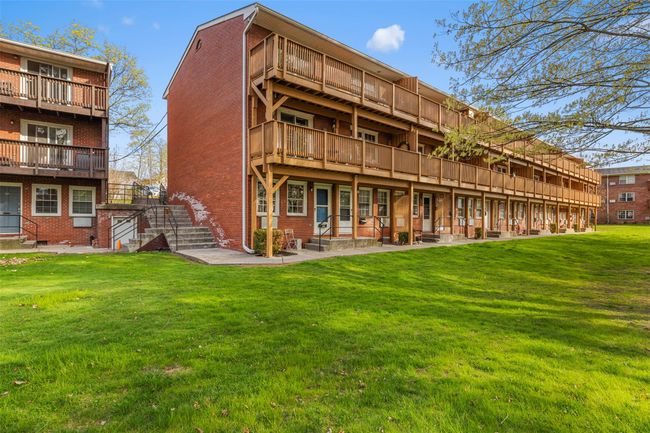 Rear view of property with a lawn, stairway, and brick siding | Image 4