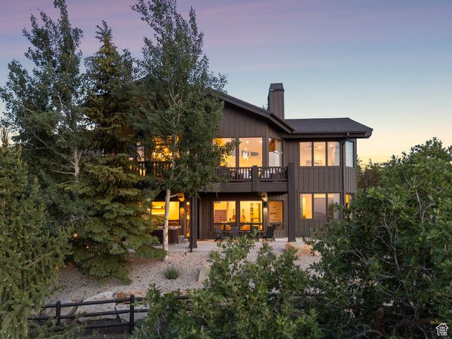 Back of property at dusk featuring a chimney, a patio area, and a wooden deck | Image 90