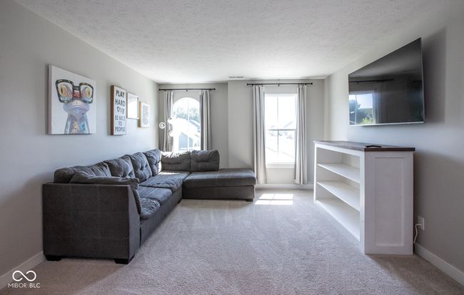 living room with carpet floors and a textured ceiling | Image 21