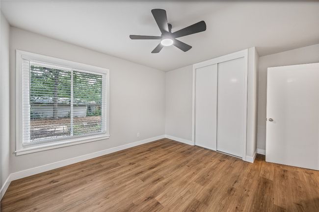 Unfurnished bedroom with light wood finished floors, a closet, and a ceiling fan | Image 9