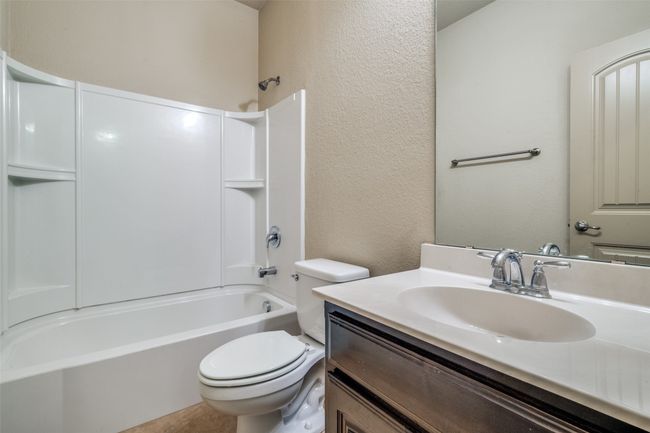 Bathroom with a textured wall, vanity, and tub / shower combination | Image 16