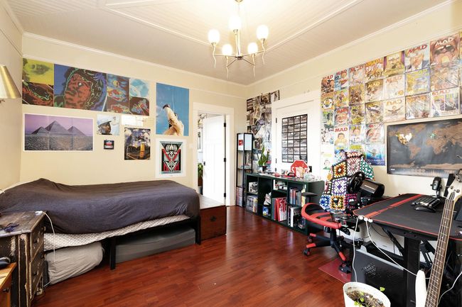 Bedroom featuring an inviting chandelier, wood finished floors, and ornamental molding | Image 22
