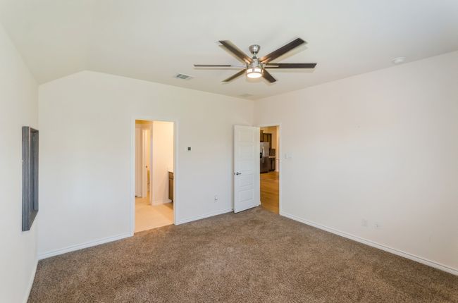 Unfurnished bedroom featuring carpet, baseboards, stainless steel fridge, and a ceiling fan | Image 18