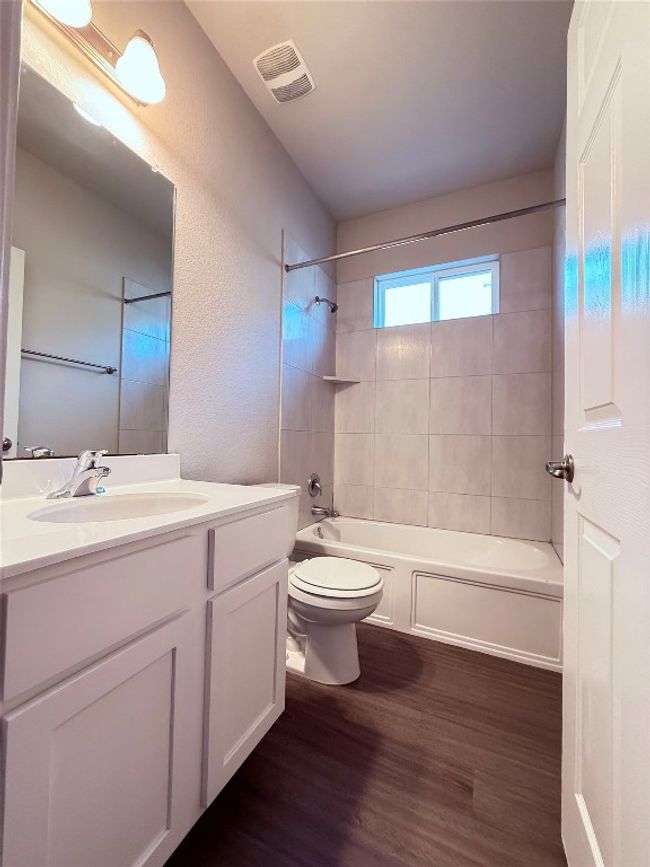 Bathroom with vanity, wood finished floors, toilet, and tub / shower combination | Image 12