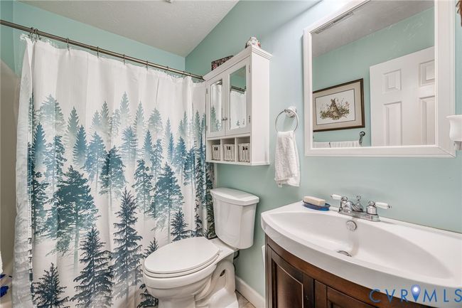 Full bath featuring a textured ceiling, vanity, and curtained shower | Image 12