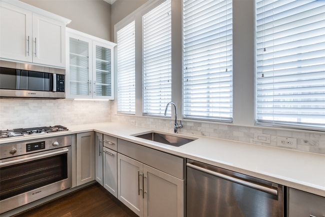 Kitchen with stainless steel appliances, backsplash, plenty of natural light, and light countertops | Image 18