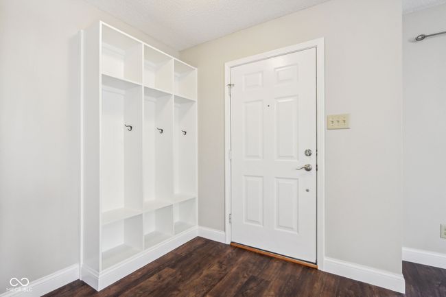 mudroom with dark wood-type flooring, baseboards, and a textured ceiling | Image 46