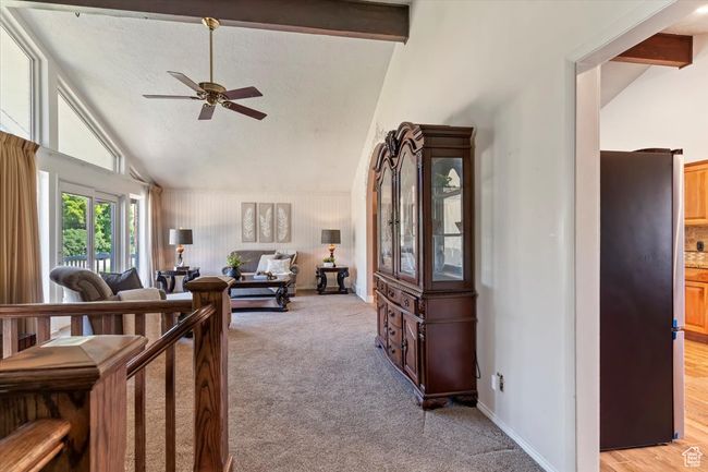 Living area with ceiling fan, light carpet, high vaulted ceiling, and beamed ceiling | Image 7