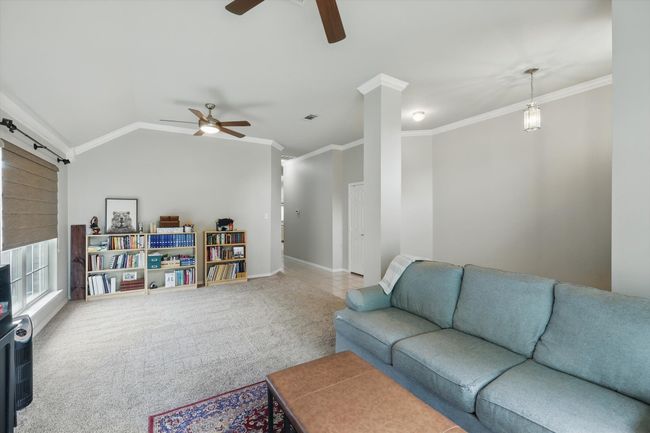 Living area featuring carpet floors, visible vents, ornamental molding, baseboards, and a ceiling fan | Image 7