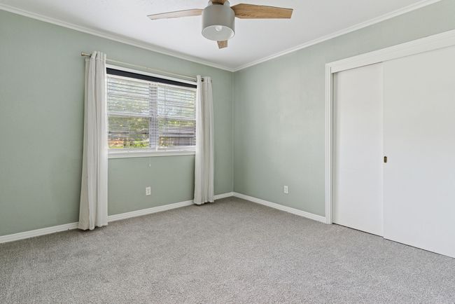 Secondary bedroom with brand new carpet and a custom ceiling fan. | Image 23