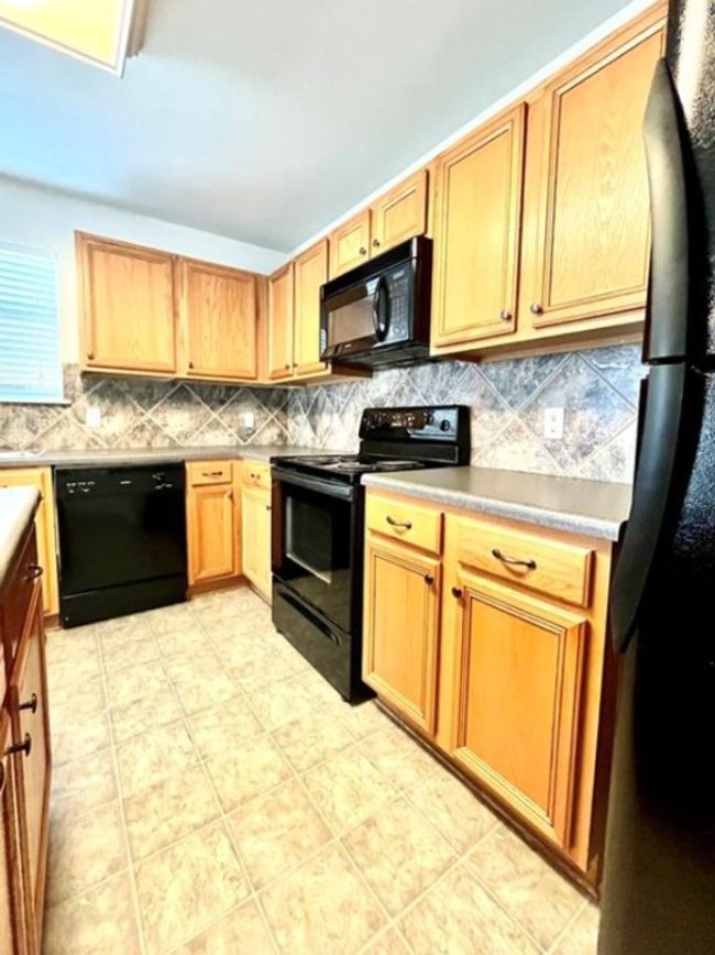 Kitchen featuring black appliances and decorative backsplash | Image 6