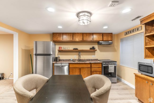 Kitchen featuring open shelves, stainless steel appliances, visible vents, and a sink | Image 27