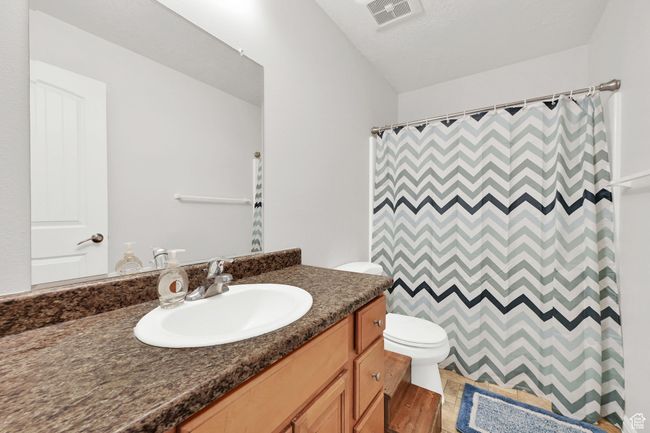 Full bath with vanity, curtained shower, toilet, and visible vents | Image 13