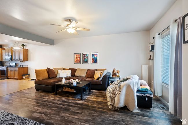 Living area featuring ceiling fan and wood finished floors | Image 6