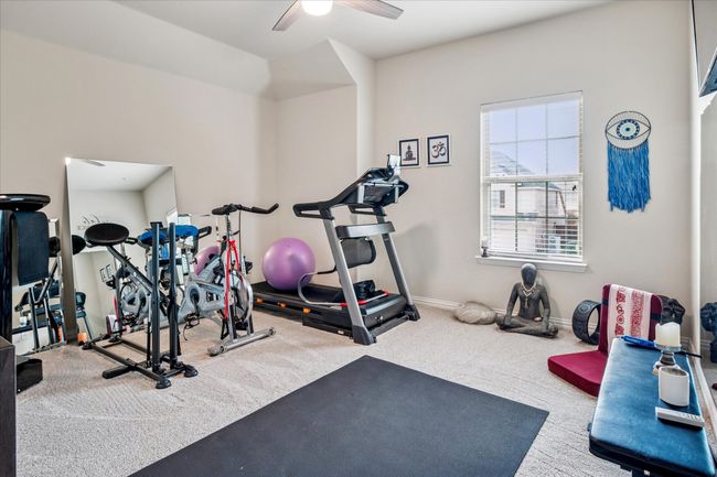 Exercise area with a ceiling fan, carpet, and baseboards | Image 24