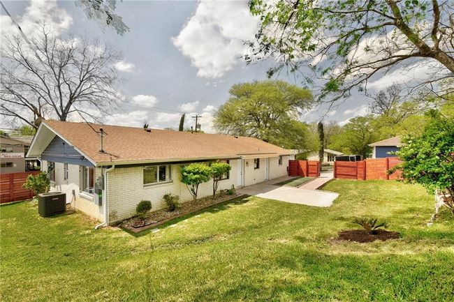Rear view of house with central AC, a shingled roof, and brick siding | Image 5