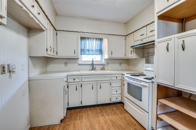 Kitchen with sink, white cabinets, electric range, and light hardwood / wood-style flooring | Image 14