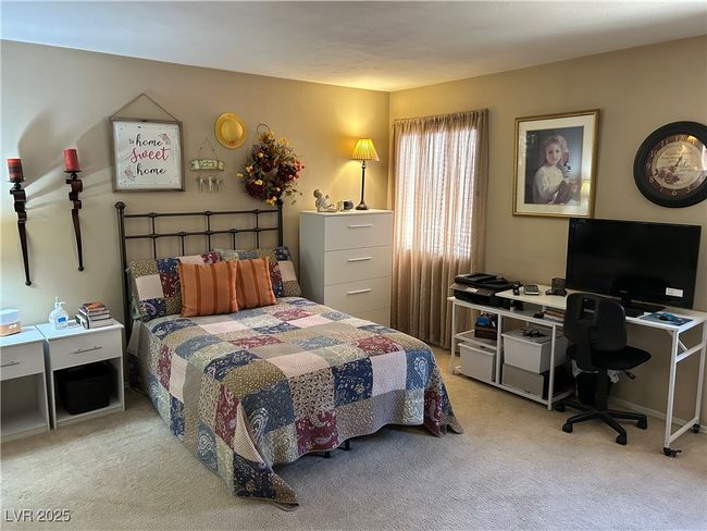 Carpeted bedroom featuring an office area | Image 19