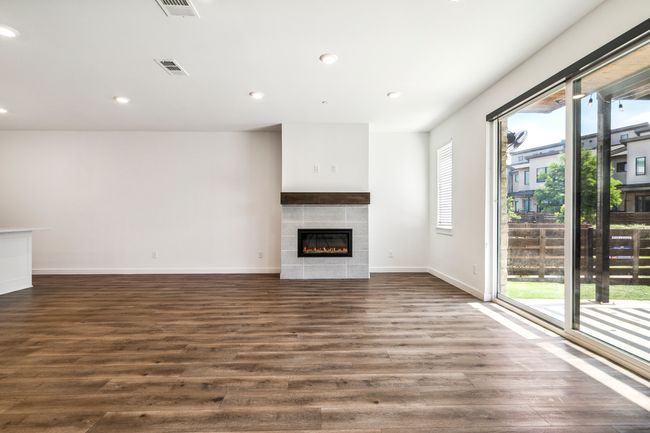 Unfurnished living room with a tile fireplace, dark wood finished floors, baseboards, and recessed lighting | Image 8