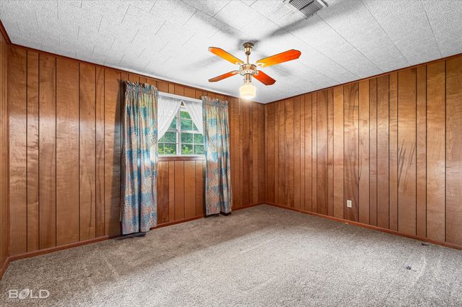 Empty room featuring ceiling fan, carpet floors, and wooden walls | Image 20