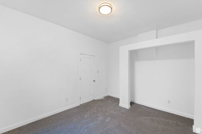 Spare room featuring baseboards and dark colored carpet | Image 18